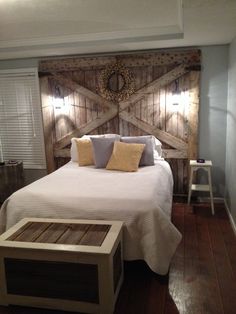 a bed with wooden headboard and pillows in a room that has wood floors on both sides