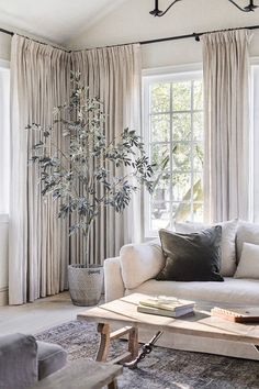 a living room filled with furniture and curtains