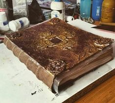 an old book sitting on top of a table next to some bottles and other items