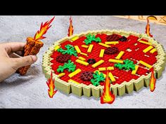 someone is playing with a lego model of a fireball pizza that looks like it's made out of legos