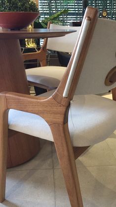 a wooden chair sitting next to a table with a bowl on it's back