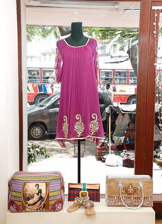 a dress and purse are on display in a window