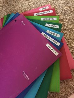 a pile of colorful folders sitting on top of a carpet