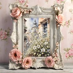 an ornate white frame with pink flowers on it in front of a wallpapered background