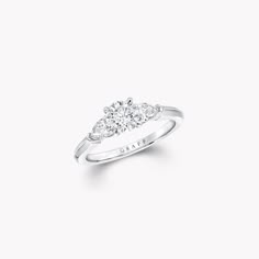 a three stone diamond ring on a white background