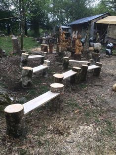 several wooden benches sitting in the middle of a yard with trees cut down to make them look like they have been carved