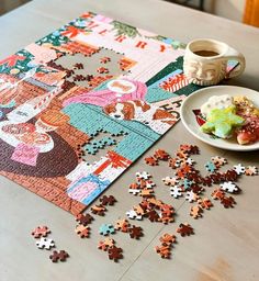 a table topped with a plate of food next to a puzzle