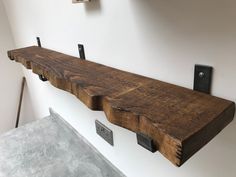 a wooden shelf with metal hooks on it and some wood planks hanging from the wall