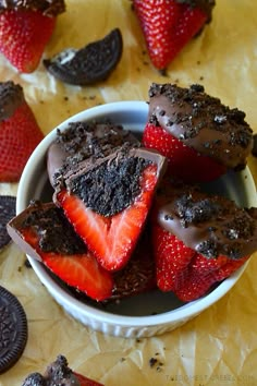 chocolate cupcakes and strawberries in a bowl with oreo cookies on the side