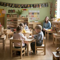 two children and an adult sitting at a table in a child's playroom