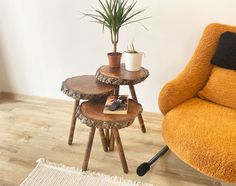 three wooden tables sitting on top of a hard wood floor next to an orange chair