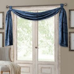 a living room scene with focus on the open door and window curtains that have been drapes pulled back