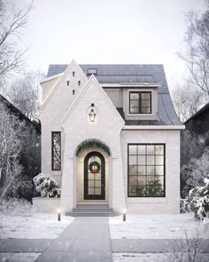 a white brick house with a wreath on the front door and two lights at the entrance