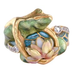 This is part of Chairish’s Fine Jewelry assortment.  Estate Masriera 18K enamel frog & water lily ring, circa 1980. This 18 karat yellow gold ring signed by Masriera features a frog and water lily design with full cut diamond accents at .08 carat total weight. The diamonds have VS1 clarity and F-G color. The Masriera ring showcases two types of fired enamel, basse taille & plique a jour water color enamel. Note some wear on the water lily. The ring is stamped C 3463 C. This enamel ring weighs 12 Water Lily Ring, Frog On Lily Pad, Plique A Jour, Frog Ring, Lily Ring, Frog Jewelry, Nouveau Jewelry, A Frog, Art Nouveau Jewelry