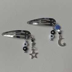 two hair clips with stars, moon and beads hanging from each one's side