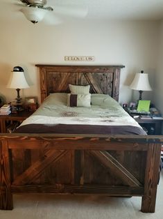 a bedroom with a bed made out of wood and two lamps on either side of the bed