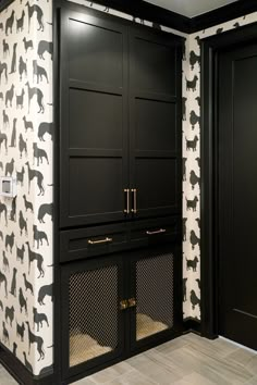 a black and white dog themed wallpaper in a room with wooden floors, built - in cabinets, and doors