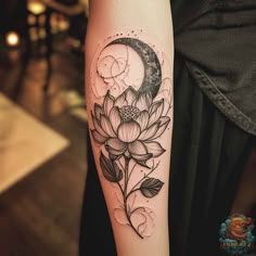 a woman's arm with a flower and moon tattoo on it