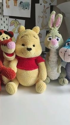 several stuffed animals are lined up on a table with pictures in the backround