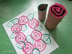 a paper towel and some crochet flowers on a green table with a cup of coffee