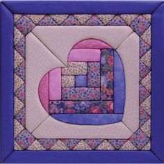 a quilted wall hanging on the side of a blue framed object with pink and purple squares