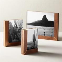 two wooden frames with cactus and mountains in the background on a white countertop, one has a black and white photo