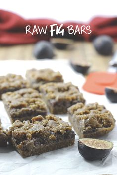 raw fig bars are cut into squares and placed on top of parchment paper next to an orange peel