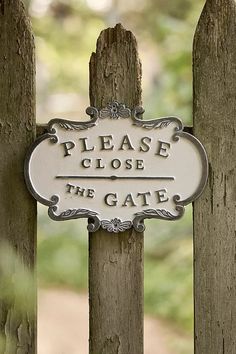 a close up of a wooden fence with a sign on it's side that says please close the gate