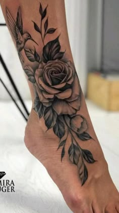 a rose and bird tattoo on the foot