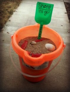 an orange bucket filled with sand and a green sign that says shore all you got