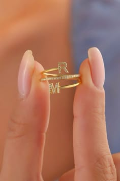 a close up of a person holding a ring with the letter n on it's side