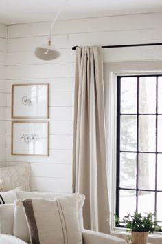 a living room with white walls and curtains