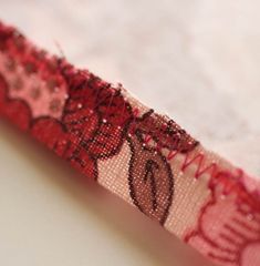 a close up of a red and black ribbon on a white surface