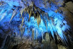 the inside of a cave with blue lights