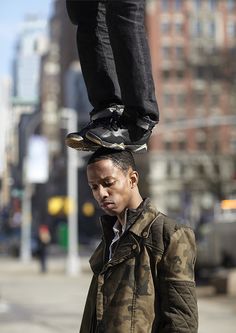 a man standing on top of another person's feet in the air with his shoes off