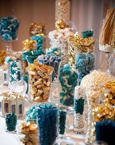 a table topped with lots of candy covered in blue and gold