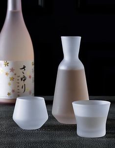 three white vases sitting next to each other on top of a carpeted floor