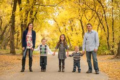 a family is posing for a photo in the park