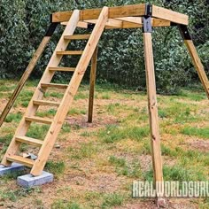 a wooden swing set with ladders in the grass