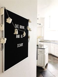 a black and white wall hanging on the side of a kitchen