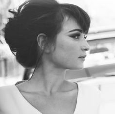 black and white photograph of a woman with her hair in a high bun, looking off to the side