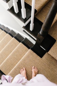 someone's feet on the floor next to some stairs