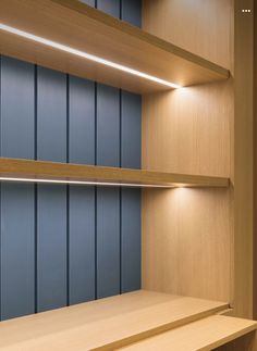 an empty wooden shelf with some lights on the top and bottom shelves in front of it