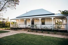 a white house sitting on top of a lush green field