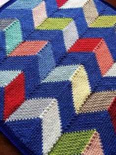 a colorful crocheted rug on top of a wooden table