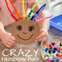 a child holding up a paper plate with colorful beads on it and the words crazy rainbow hair