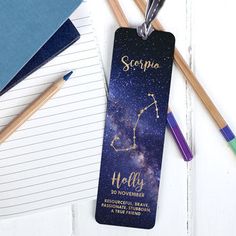 a personalized bookmark with the name and zodiac sign on it next to pencils