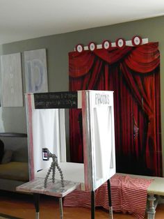 a photo booth with red curtains and white chairs