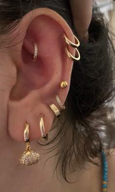 a woman with ear piercings on top of her head and behind her ear is an earring