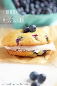 a blueberry whoopie pie is sitting on wax paper with berries in the background